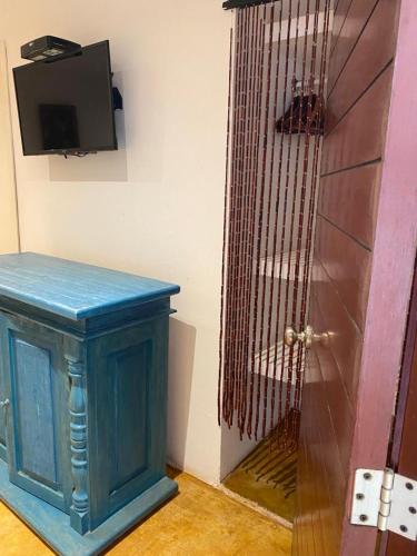 a door to a room with a bird cage next to it at Casa de las Olas Surf & Beach Club in Acapulco