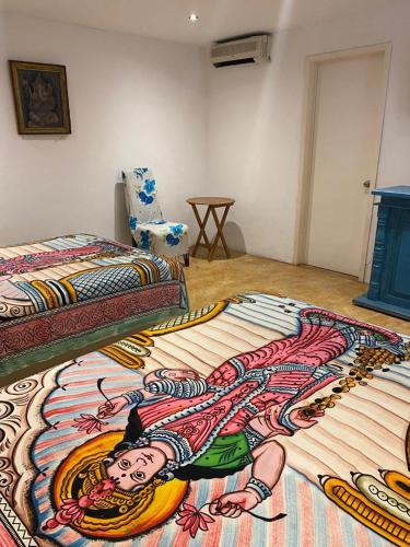 a bedroom with a bed with a painting on it at Casa de las Olas Surf & Beach Club in Acapulco