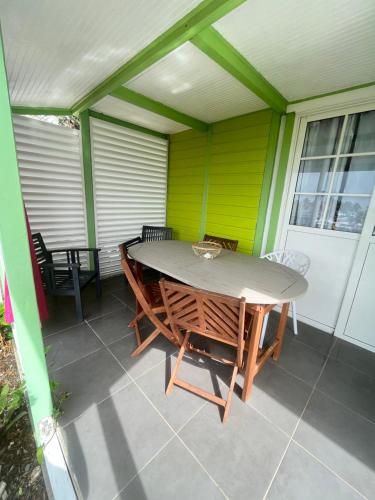 a table and chairs on the back porch of a house at Les algues de La Chapelle Bleu horizon in Anse-Bertrand