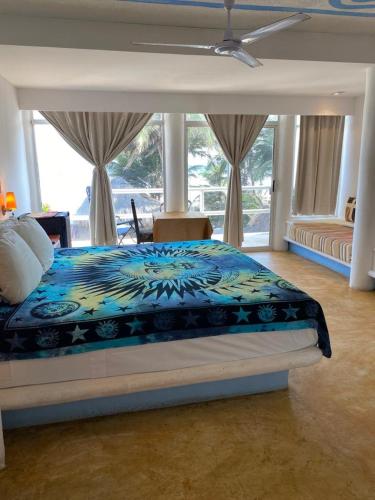 a bedroom with a bed with a blue comforter at Casa de las Olas Surf & Beach Club in Acapulco