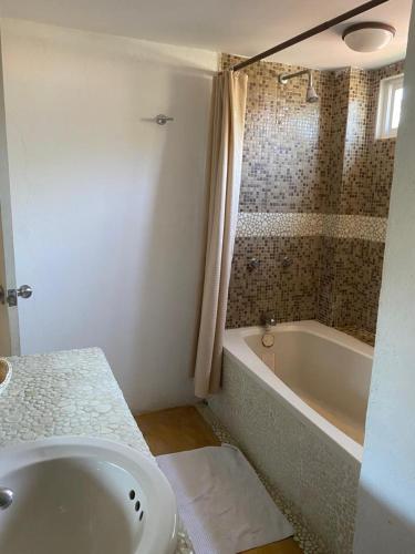 a bathroom with a sink and a bath tub at Casa de las Olas Surf & Beach Club in Acapulco