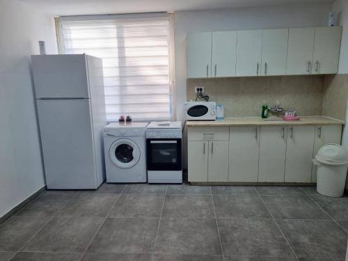 a kitchen with a white refrigerator and a dishwasher at דירה מקסימה in Eilat