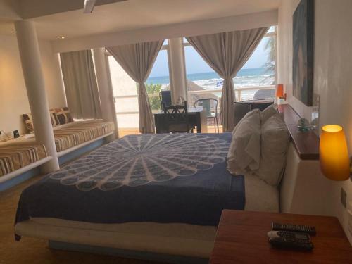 a bedroom with a bed with a view of the ocean at Casa de las Olas Surf & Beach Club in Acapulco