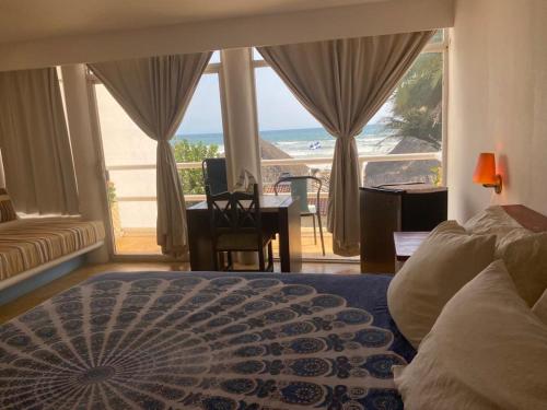 a bedroom with a bed and a view of the ocean at Casa de las Olas Surf & Beach Club in Acapulco