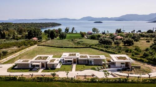 an aerial view of a large house with a view of the water at VARKO LUXURY SUITES in Paleros