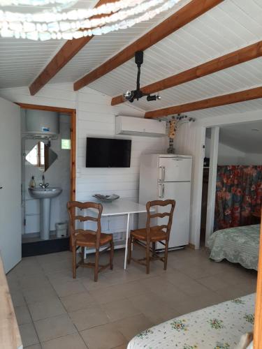 a kitchen with a desk and two chairs and a sink at Chalet au pied du Mont Ventoux in Mormoiron