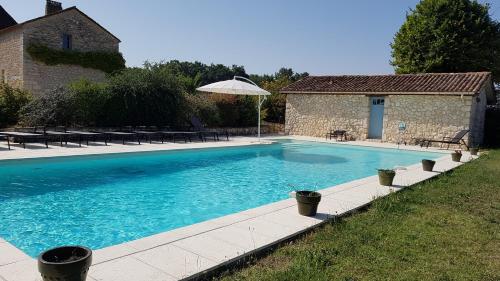 einen Pool im Garten mit Sonnenschirm in der Unterkunft Chambre d'hôte la source in Conne-de-Labarde