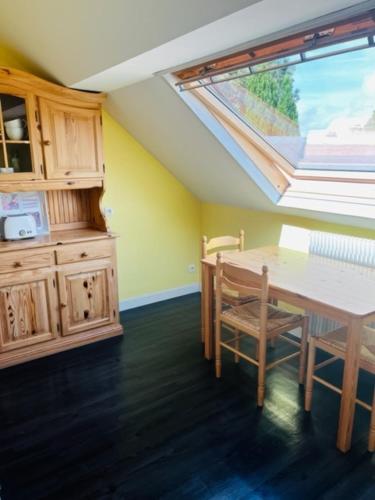 une cuisine avec une table et une lucarne dans l'établissement Appartement Entre ville et nature, à Saint-Étienne-au-Mont