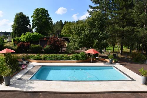- une piscine dans une cour avec des arbres et une maison dans l'établissement La Californie, à Changé