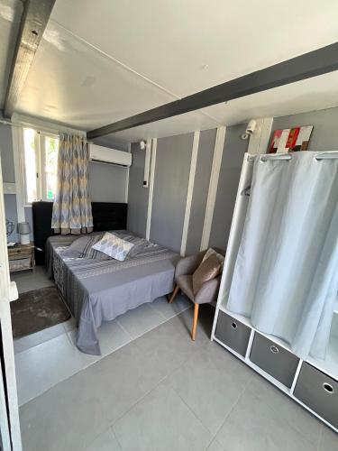 a bedroom with a bed and a chair at Les algues de La Chapelle Bleu horizon in Anse-Bertrand