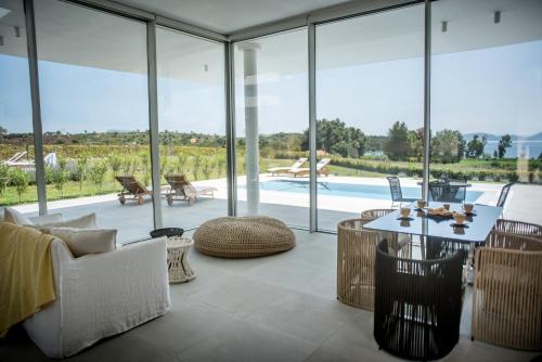 a living room with glass windows and a pool at VARKO LUXURY SUITES in Paleros