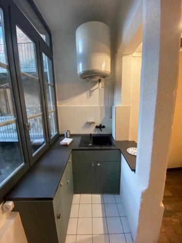 a kitchen with a black counter and a sink at En cœur de ville in Chambéry