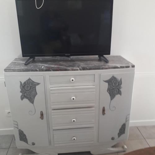 a tv on a dresser with a tv on top at An ti koz in Plouguerneau