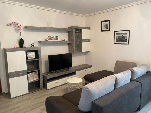 a living room with a couch and a flat screen tv at NUEVO!!! PISO CENTRICO EN SUANCES -Sol Luxury- in Suances