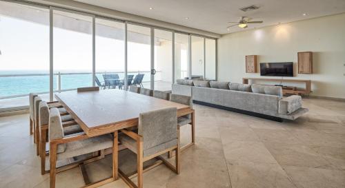 a dining room with a table and a couch at Luna Blanca Penthouse by Kivoya in Puerto Peñasco