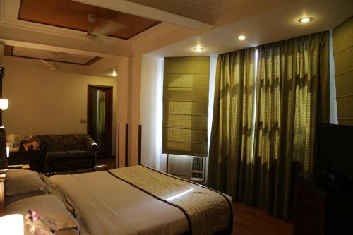 a hotel room with a bed and a television at Hotel Park Residency in New Delhi