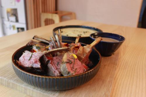 a bowl of meat and a bowl of dipping sauce at Kapera Maison d'Hotes in Macaye