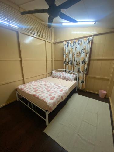 a small bed in a room with a ceiling fan at ORKED LUDICIA 2 bedroom Village Cottage house in Kuala Terengganu