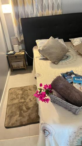 a bed with a basket with flowers on it at Les algues de La Chapelle Bleu horizon in Anse-Bertrand