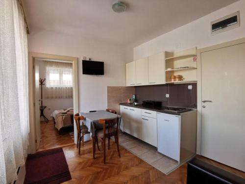 a kitchen and dining room with a table and a room at Smeštaj Luka in Soko Banja