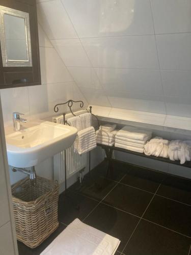 a bathroom with a sink and a mirror and towels at BBOosterweg3 Studio in Heemskerk