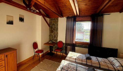 a bedroom with a bed and two chairs and a window at Kateřina restaurant a penzion in Rozvadov