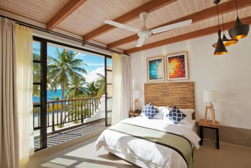 
a bedroom with a large bed and a large window at Crystal Sands in Maafushi
