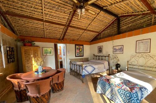 1 Schlafzimmer mit 2 Betten, einem Tisch und einem Bett in der Unterkunft Jardín Quinta Las Fuentes Cabañas, Valsequillo. PUEBLA in Puebla