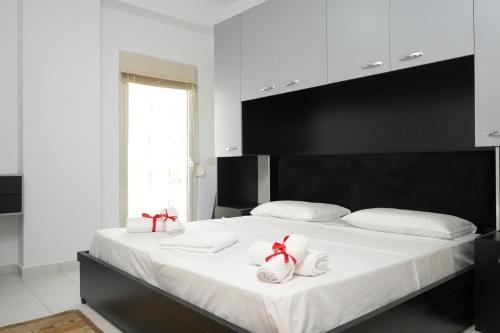 ein Schlafzimmer mit einem großen weißen Bett und zwei weißen Handtüchern in der Unterkunft Merry's Apartment in Durrës