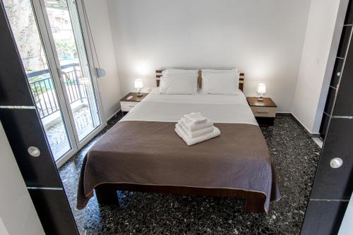 a bedroom with a bed with two towels on it at Fantastic location who love sea and center in Athens