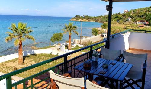 balcón con mesa, sillas y vistas al océano en Tonias Houses - Thea House and Vrachos Attic Appartment, en Alikanas