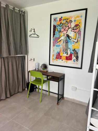 a room with a desk and a painting on the wall at Nomada Beach Hostel- Isla Verde in San Juan
