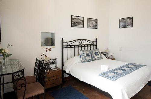 a bedroom with a bed and a table and a chair at Quinta Alhóndiga Galindo Hotel Boutique in Cholula
