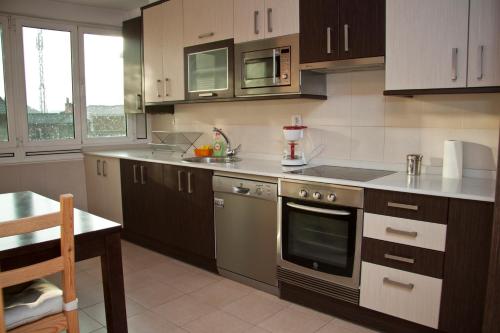 a kitchen with a stove and a counter top at Residencial Arbeyal in Gijón