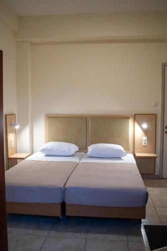 a bedroom with a large bed with two pillows at Sweetmar guest Rooms-ground floor in Kos Town