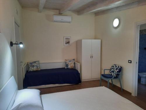 a bedroom with a bed and a chair in it at Villetta del Poggio in Marina di Camerota