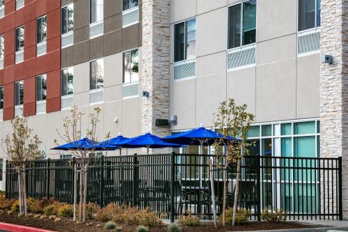 a fence with blue umbrellas in front of a building at Holiday Inn Express & Suites - Bend South by IHG in Bend