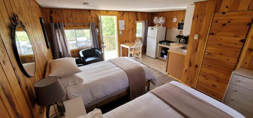 a small bedroom with two beds and a kitchen at Parkway Cottage Resort and Trading Post in Dwight