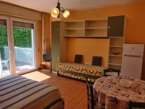 ein Schlafzimmer mit einem Bett und einem Tisch in einem Zimmer in der Unterkunft Residenza Il Poggio in San Bartolomeo al Mare