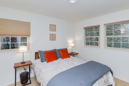 Monte Rio的住宿－Redwood Paradise，一间卧室配有一张带两盏灯的床和两扇窗户。