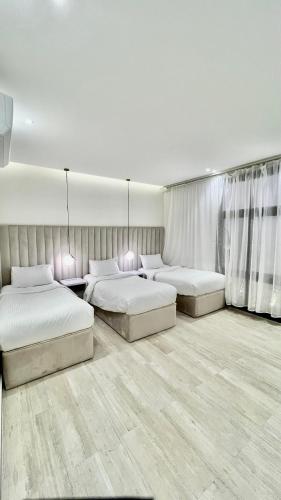 a bedroom with two beds and two lamps in it at شاليهات سنتارا in Taif