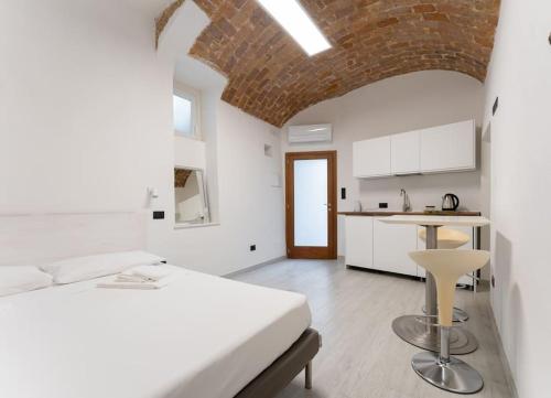 テルモリにあるLe Dimore nel Borgo di Termoliの白いベッドルーム(ベッド1台付)、キッチンが備わります。
