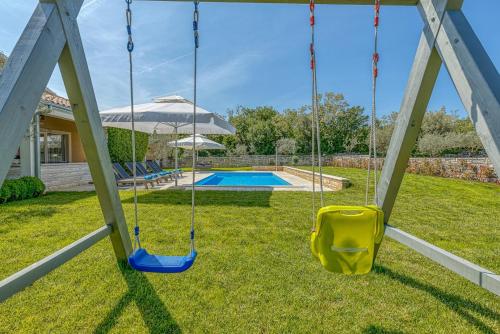 a swing in a yard next to a pool at Villa Ruza in Selina