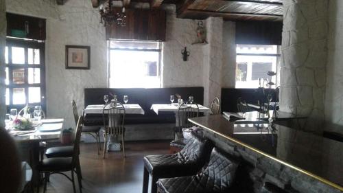 a room with two tables and chairs and two windows at HOTEL Quito Antiguo in Quito