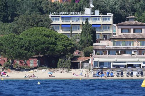 a hotel on the beach with people on the beach at Cap Nègre Hôtel in Le Lavandou