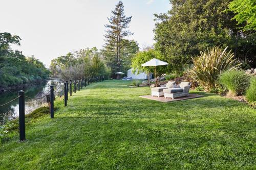 a garden with a couch and an umbrella in the grass at Milliken Creek Inn in Napa