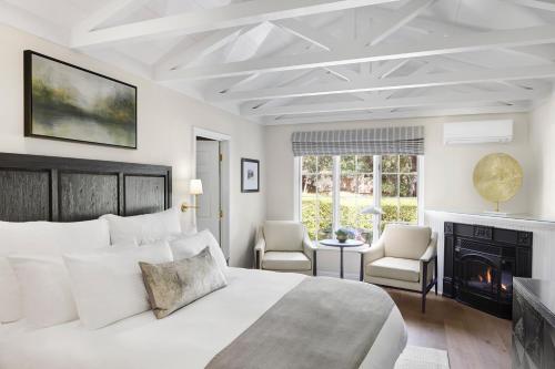 a white bedroom with a bed and a fireplace at Milliken Creek Inn in Napa