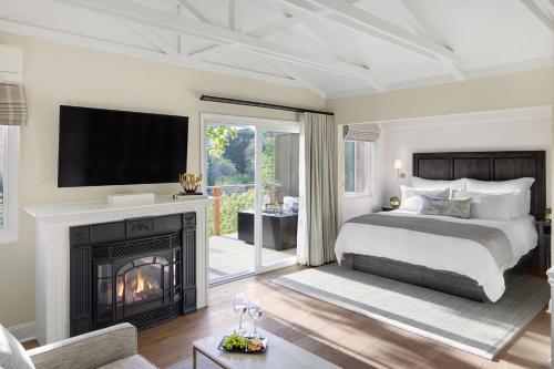 a bedroom with a bed and a fireplace with a television at Milliken Creek Inn in Napa