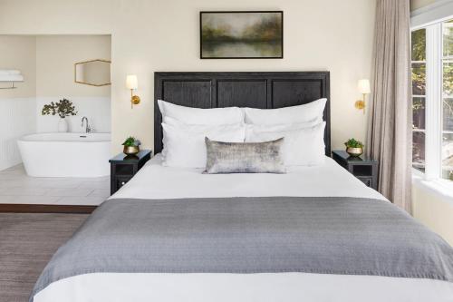 a bedroom with a large bed and a bath tub at Milliken Creek Inn in Napa
