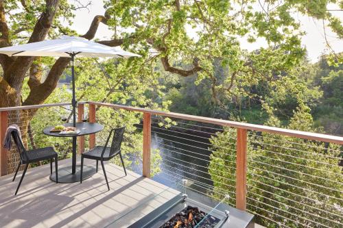 a deck with a table and chairs and an umbrella at Milliken Creek Inn in Napa